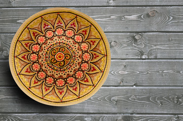Decorative ceramic plates hand painted dot pattern with acrylic paints on a gray wooden background. Copy space.