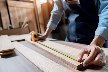 Carpenter working with equipment on wooden table in carpentry shop. woman works in a carpentry shop.