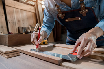 Carpenter working with equipment on wooden table in carpentry shop. woman works in a carpentry shop.