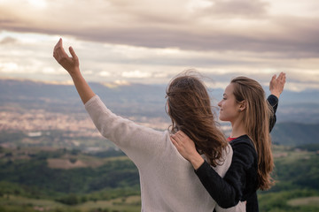 Christian worship and praise. Two young woman are praying and worshiping in the evening.
