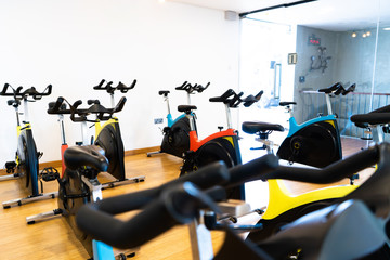Fototapeta premium spinning exercise bikes gym room with many in a row