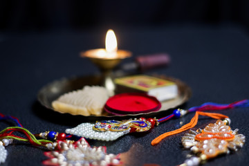 a plate thali decorated with rakhi sweet lamp diya for the occasion of rakshabandhan greeting of brother and sister