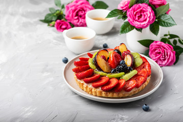 Obraz na płótnie Canvas Tart with strawberries, kiwi, plums and cream