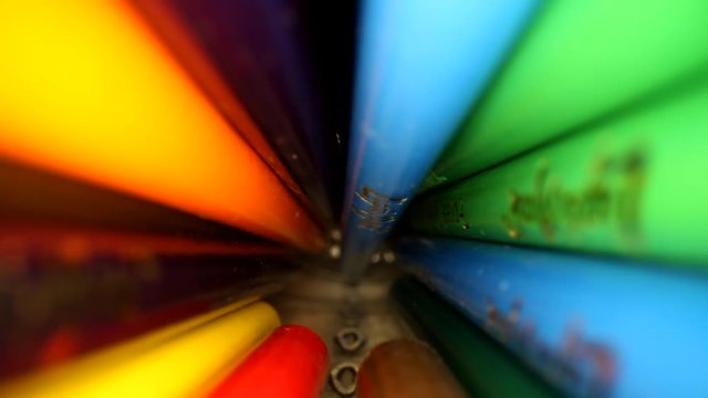 Moving out a jar of colored pencils, starting at the bottom and finishing to reveal the tips. Using a wide angle probe lens to get a unique perspective.