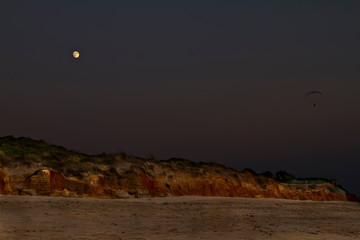 full moon paragliding on the beach