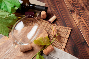Glass bottle of wine with corks on wooden table background - Image