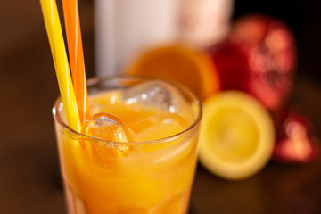 orange long drink on wooden table closeup
