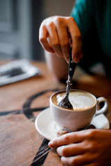 the girl is waiting for a meeting and drinks cappuccino