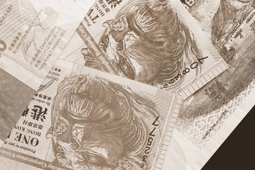 Different Hong Kong dollars bills on a dark background close up. Money background brown color toned
