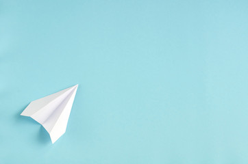 White paper plane on blue background composition.