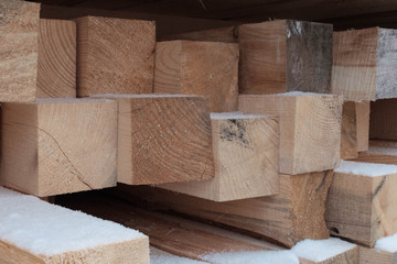 Piled lumber in the outdoor warehouse in the winter