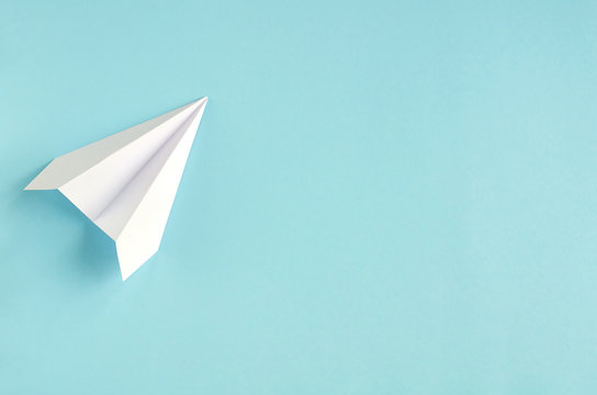 White paper plane on blue background composition.
