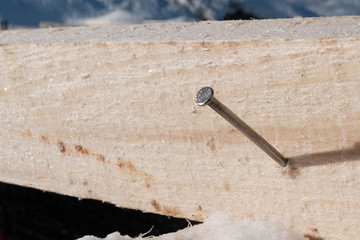 Steel nail hammered in the wooden beam