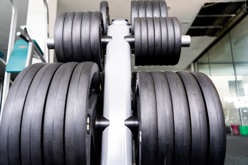 Sports equipment in gym Barbells of different weight on rack