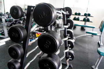 Sports equipment in gym Barbells of different weight on rack