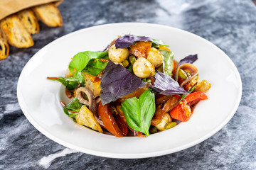 Tasty salad bowl with mozarella, vegetables, basil, spinach. Healthy food for lunch. Italian restaurant food style. Marble table. Picture for recipe. Healthy, vegan food