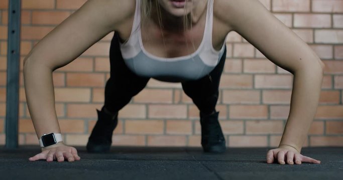 Athletic woman in Gym, girl performs explosive push ups, clapping push in slow motion, crossfit.