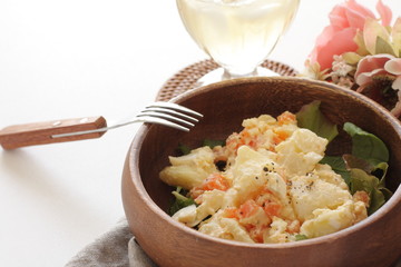 Potato and carrot salad on wooden bowl
