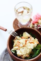 Potato and carrot salad on wooden bowl