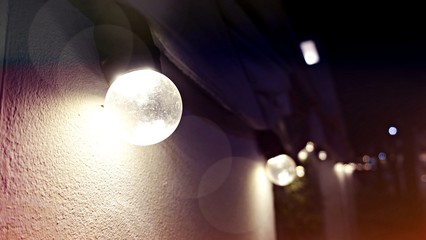 Burning garlands garland on a cement wall background. Light bulbs on night background. Bulbs For Parties Or Wedding