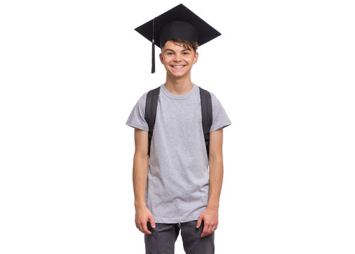 Young Graduate Student - Happy Teen Boy In Bachelor Hat With Backpack, Isolated On White Background. Smiling Child In Corner-Cap Looking At Camera. Teenager Guy In Graduation Cap Back To School.