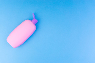Flat lay composition of baby care products on a blue background. View from above shampoo or shower bottle gel