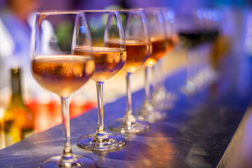 Many glasses of different wine on bar counter