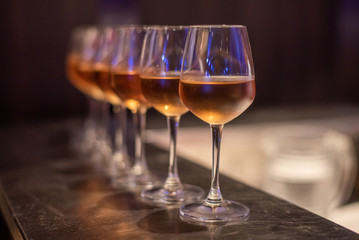 Many glasses of different wine on bar counter