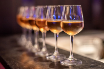 Many glasses of different wine on bar counter