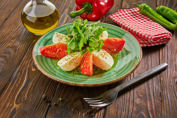 Italian caprese salad with tomatoes and mozzarella cheese on wooden table