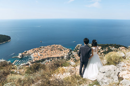 A couple is looking at a beautiful view of Dubrovnik in Croatia. They have a honeymoon
