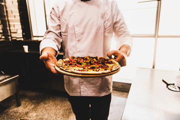 A chef is serving a pizza