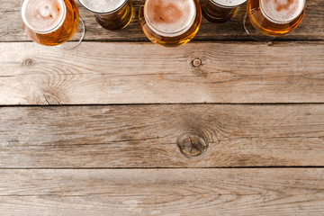 Overhead shot of beer glasses on wooden table.