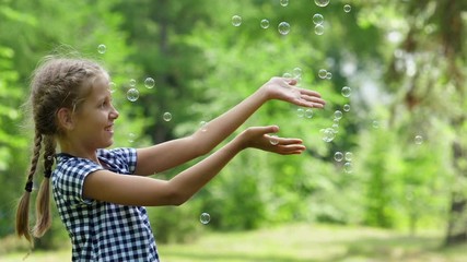 Girl playing with soap bubbles. Outdoor. Slow motion.