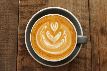 a cup of latte art coffee on wooden background                              