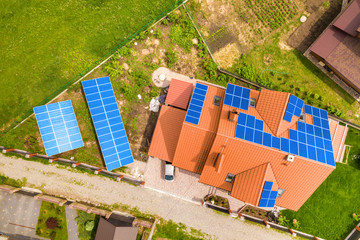 Aerial top view of new modern residential house cottage with blue shiny solar photo voltaic panels...