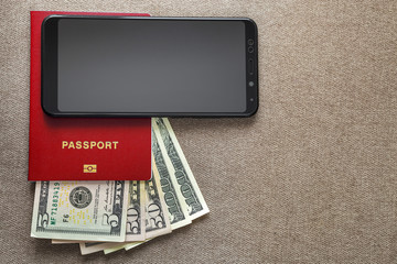 Modern black cellphone, money dollars banknotes bills and passport on copy space background. Travel light, comfortable journey concept.