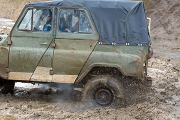 Rally on Russian SUVs in the mud in winter, Trapped all-terrain vehicle pulled out of the river	