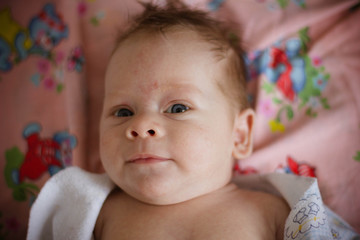 portrait of a baby lying on bed