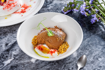 Selective focus on tasty chocolate ice cream with sea salt and microgreen. Restaurant style modern ice cream. Sweet dessert after lunch. Flat lay marble table. Two tasty desserts