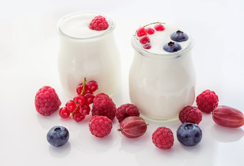 Different ripe berries and homemade yogurt on a white light background.. Good breakfast.  soft selective focus.