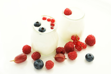 Different ripe berries and homemade yogurt on a white light background.. Good breakfast.  soft selective focus.