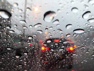 Rain makes traffic jam on work day, everyone goes to work late, driving with caution for safety.