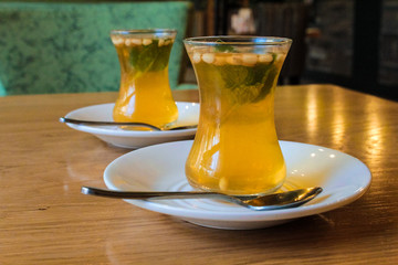 Turkish citrus tea in small cups, with the addition of pine nuts and mint leaves. European recipe