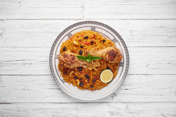 Chicken Kabsa or Chicken biryani at white wooden background. Kabsa is traditional saudi arabian...