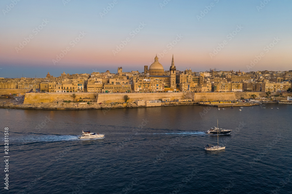 Wall mural valletta - capital of malta. aerial view of valletta skyline in the evening, sunset. boats on the se