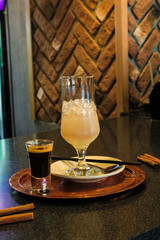 A drink consisting of Baileys liqueur and a drink of mineral water, sweet syrup with ice and a straw. European recipe