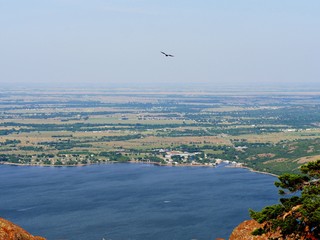 Aerial view of Lake Lawtonka, seen from the peak of Mt. Scott, Oklahoma, USA, with a bird flying in the skies.