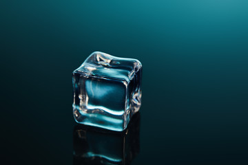 pure transparent ice cube on emerald background