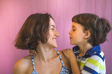 Cute boy kisses and hugs mom.